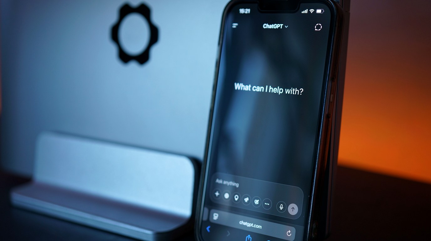 Smartphone mit KI-Chat-Interface auf dem Display, heller neutraler Hintergrund