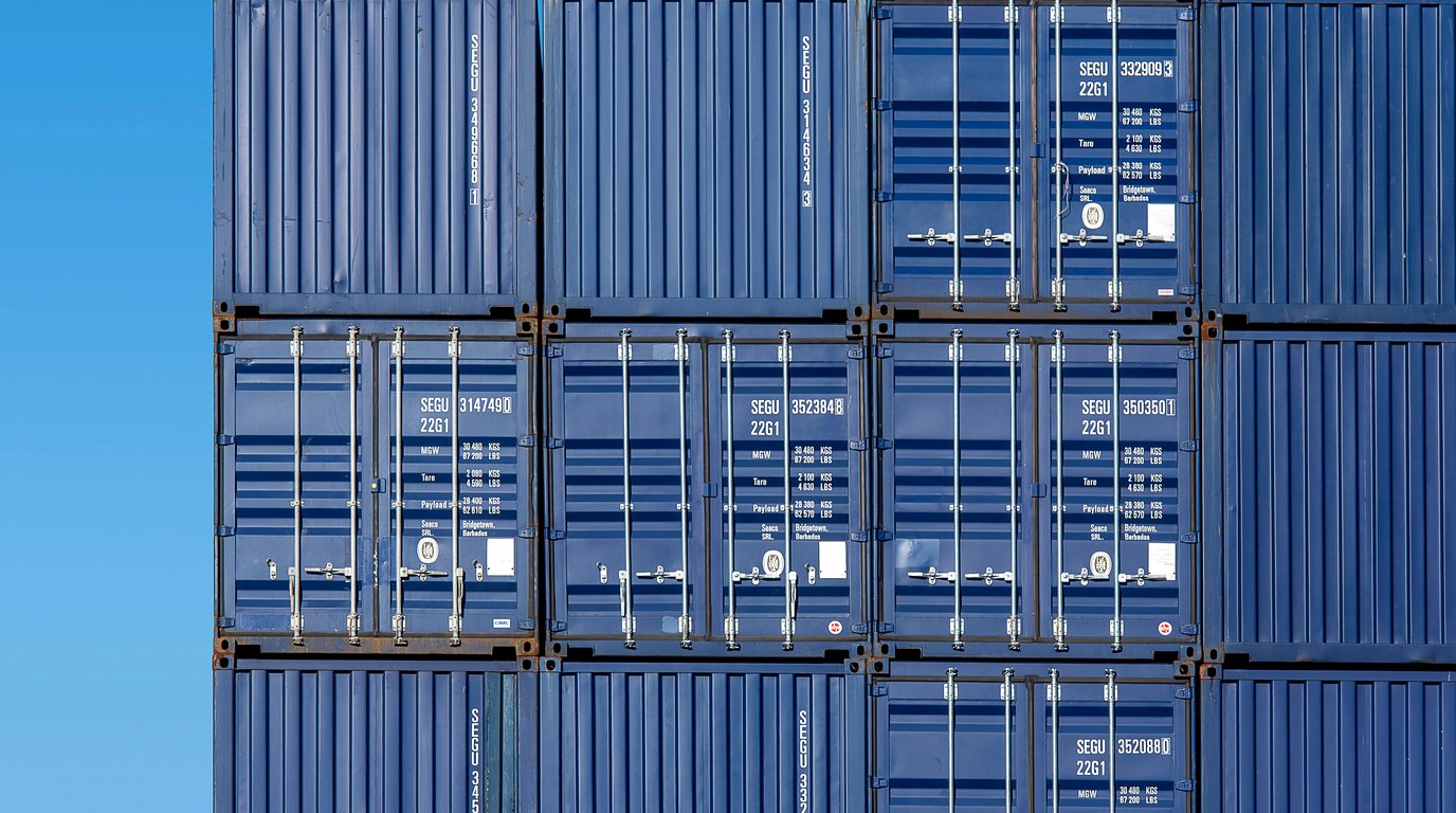 Gestapelte Frachtcontainer im Rotterdamer Hafen, sinnbildlich fuer Lieferkettenabhaengigkeit und Vendor-Risiko