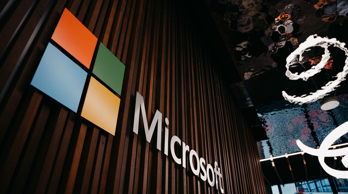 Bürowand mit Microsoft-Firmenlogo in Silber auf grauem Untergrund