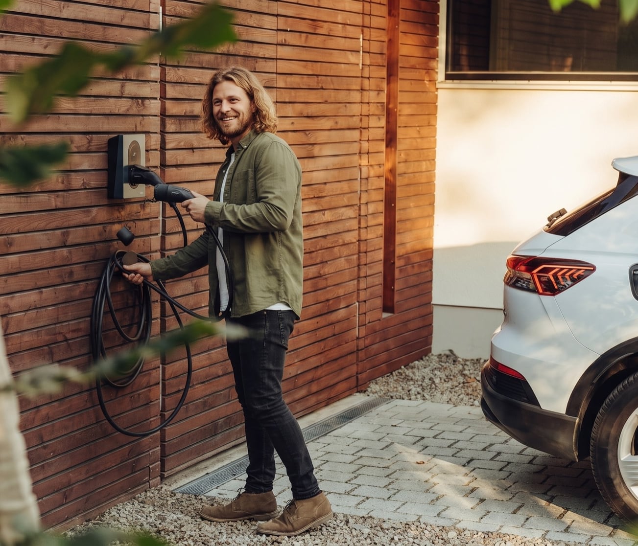 Mann laedt sein Elektroauto an der privaten Wallbox, VoltExchange-Case von Collective Brain