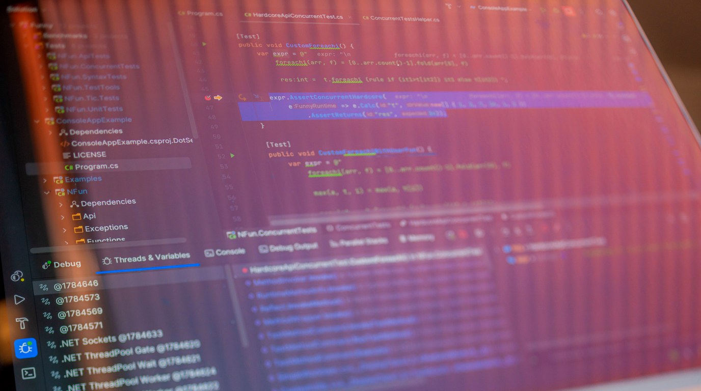Bildschirm mit Programmcode und Debugger-Ansicht einer Entwicklungsumgebung in rötlichem Licht